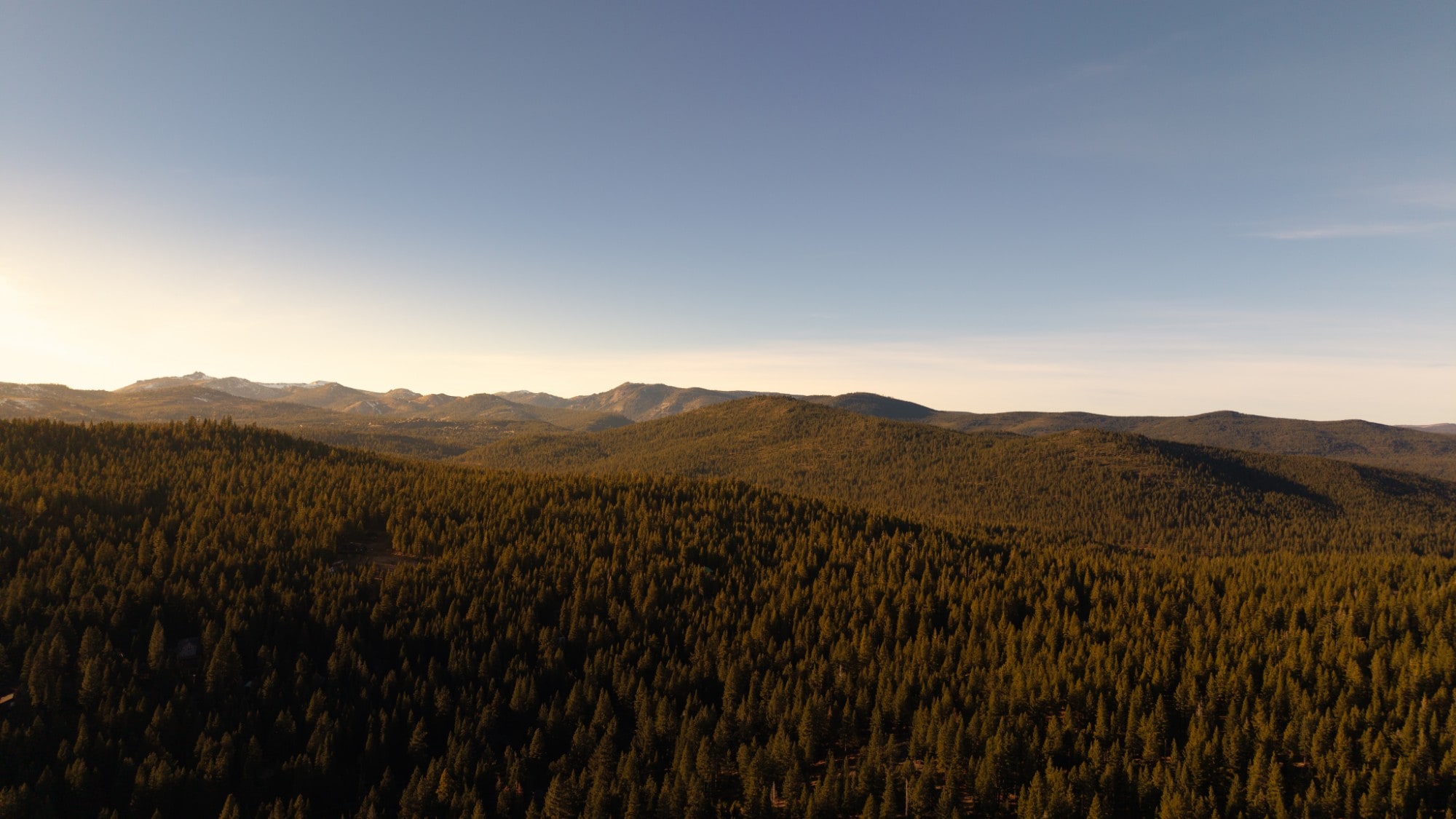 Forested ridges above Lake Tahoe at golden hour, photographed by The Visaro